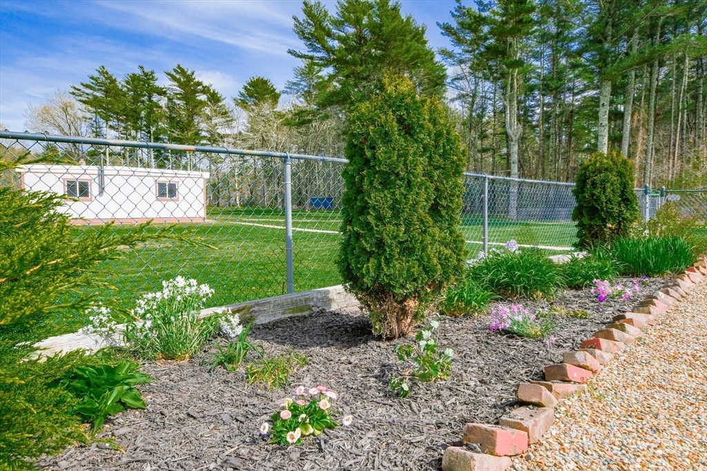 60 Mendell Road Rochester, MA 02770 - Photo 14 of 42 a view of a garden with a bench in the garden