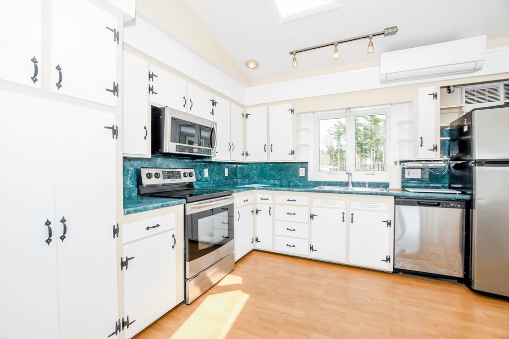 60 Mendell Road Rochester, MA 02770 - Photo 16 of 42 a kitchen with stainless steel appliances granite countertop a refrigerator a stove a sink and white cabinets with wooden floor