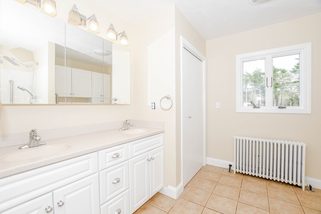 60 Mendell Road Rochester, MA 02770 - Photo 31 of 42 a bathroom with a sink a mirror and a window