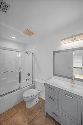 a spacious bathroom with a double vanity sink toilet mirror and shower