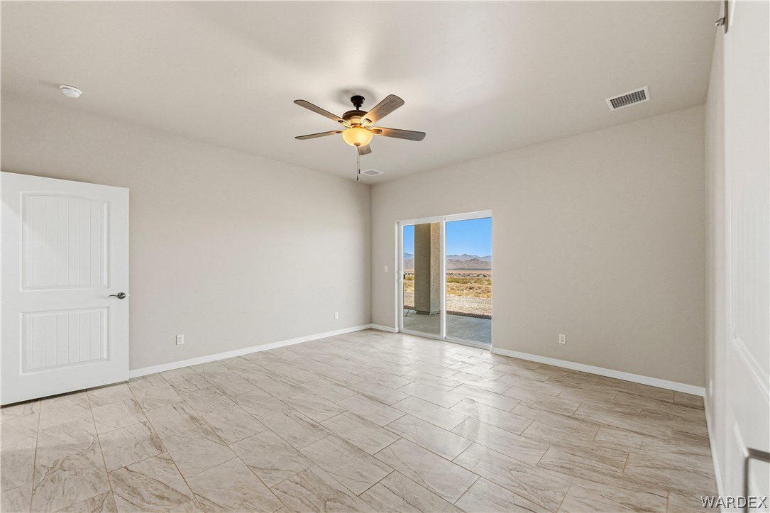 9818 North Cyrus Road Kingman, AZ 86401 - Photo 15 of 42 a view of an empty room with a ceiling fan and a window