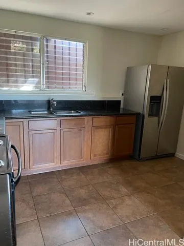 a kitchen with granite countertop a refrigerator a sink a washer and dryer