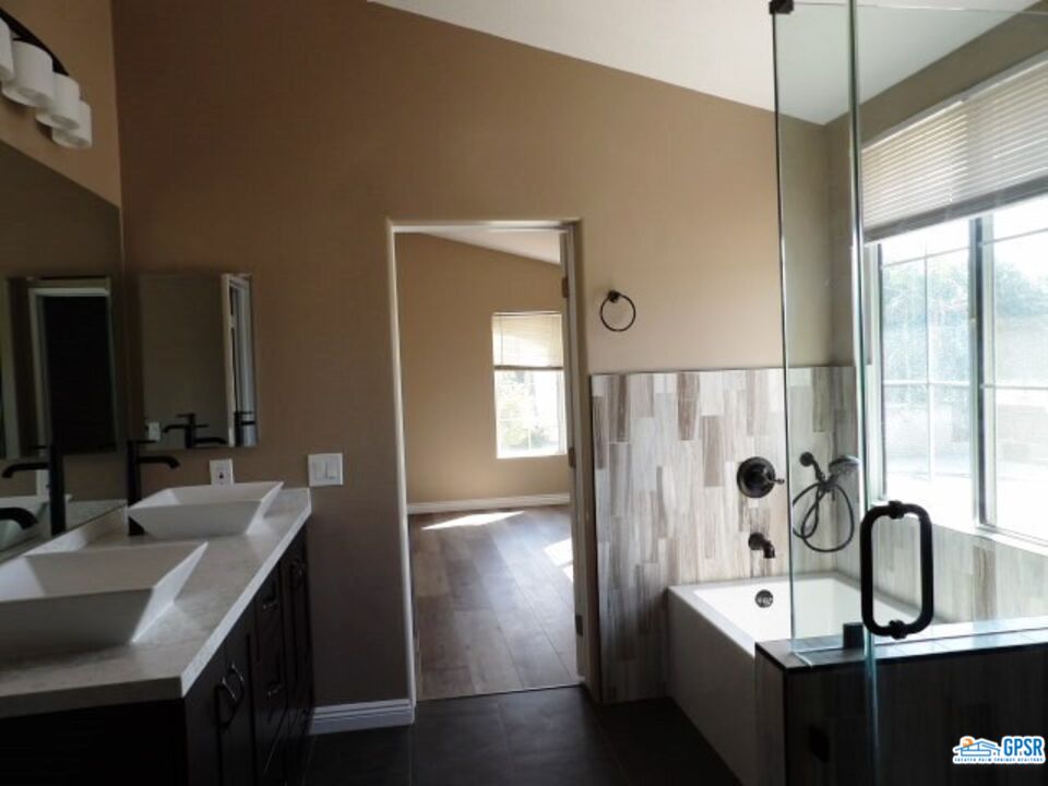 2703 Titania Place Simi Valley, CA 93063 - Photo 8 of 20 a bathroom with a double vanity sink a mirror and a bathtub