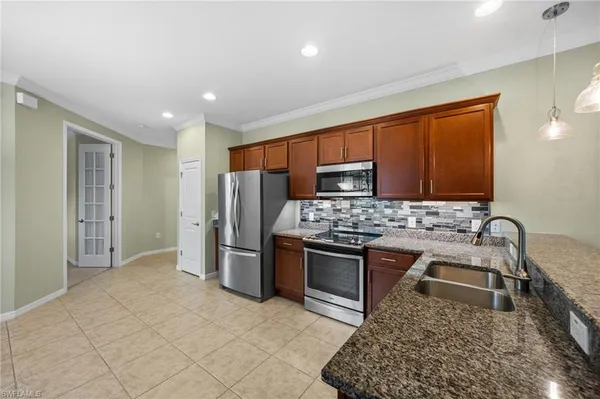 a kitchen with stainless steel appliances granite countertop a stove a sink and a refrigerator