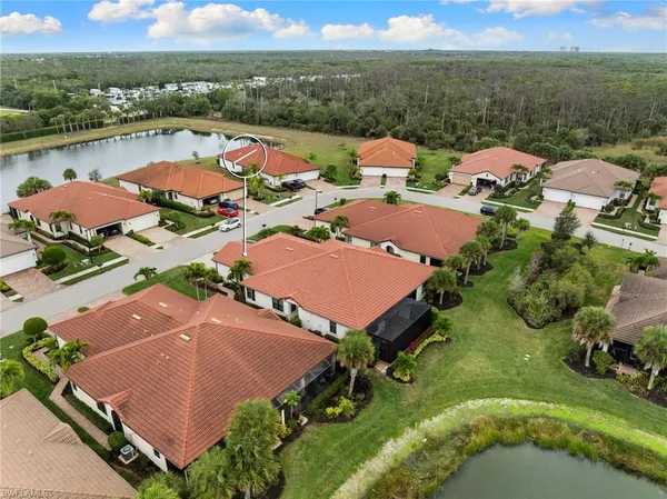 an aerial view of a city with lots of residential buildings ocean and mountain view in back