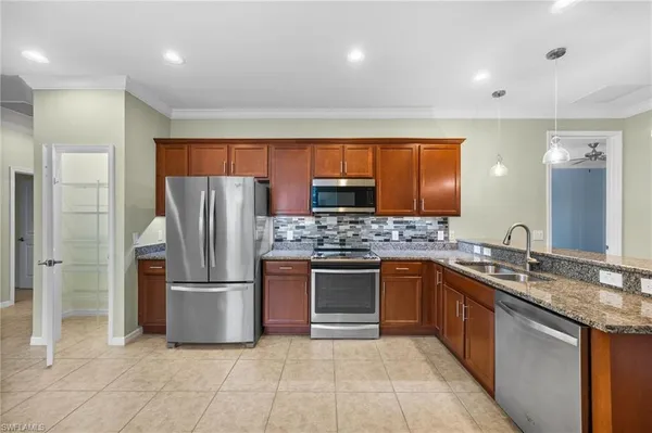 a kitchen with stainless steel appliances granite countertop a refrigerator and a sink