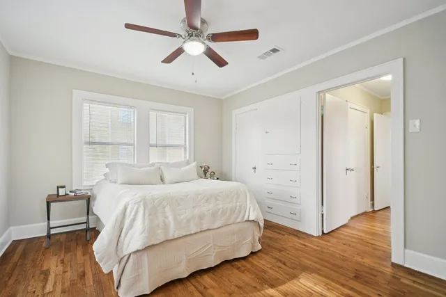 a bedroom with a large bed closet and wooden floor
