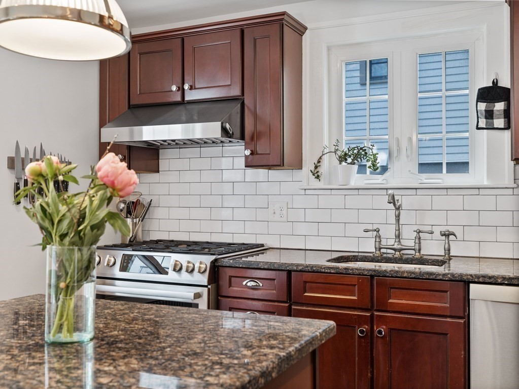 4 Malcolm Road Boston, MA 02130 - Photo 11 of 34 a kitchen with stainless steel appliances granite countertop a sink a stove and a wooden cabinets