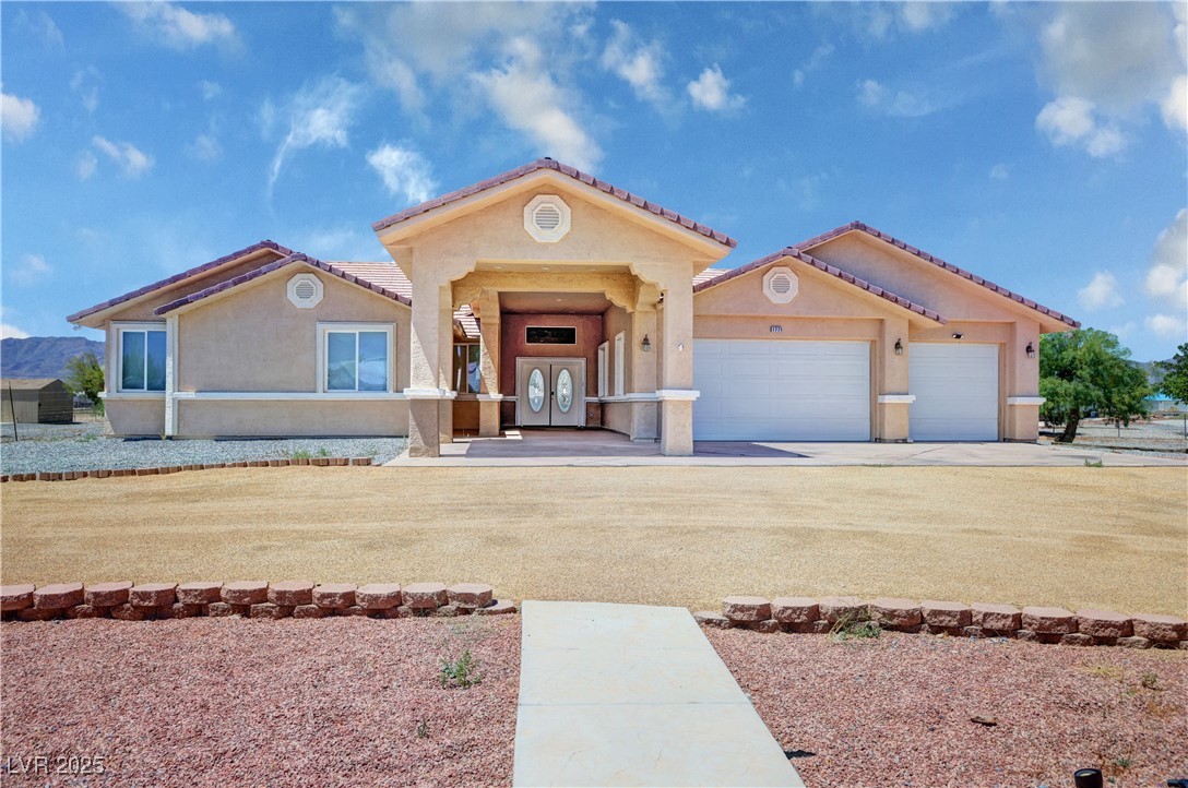 1771 Labrador Street Pahrump, NV 89048 - Photo 1 of 64 Mediterranean / spanish home featuring stucco siding, an attached garage, a tiled roof, and concrete driveway