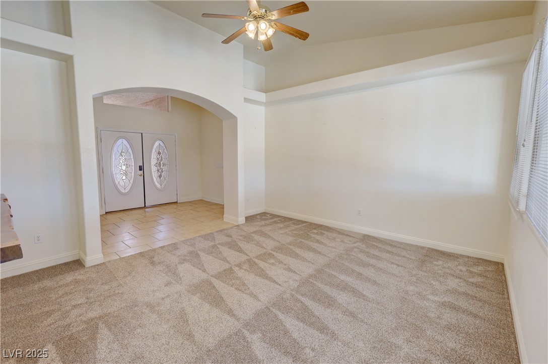 1771 Labrador Street Pahrump, NV 89048 - Photo 11 of 64 Entrance foyer with arched walkways, carpet flooring, ceiling fan, tile patterned floors, and high vaulted ceiling