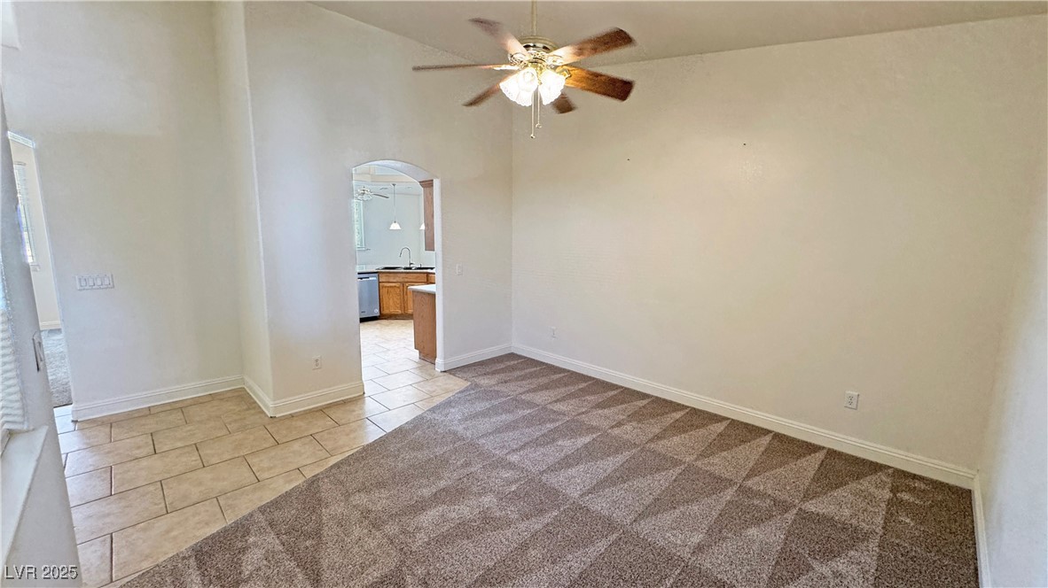 1771 Labrador Street Pahrump, NV 89048 - Photo 15 of 64 Unfurnished room with ceiling fan, light tile patterned floors, a towering ceiling, and light carpet