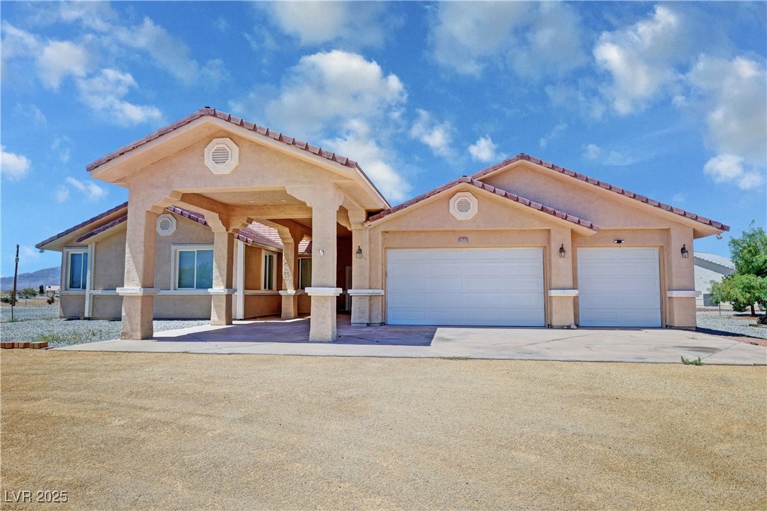 1771 Labrador Street Pahrump, NV 89048 - Photo 2 of 64 Mediterranean / spanish home with driveway, an attached garage, stucco siding, and a tiled roof