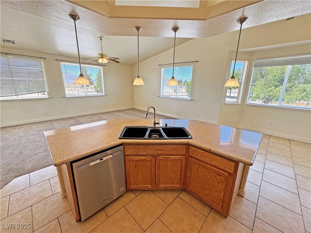 1771 Labrador Street Pahrump, NV 89048 - Photo 63 of 64 Kitchen featuring stainless steel dishwasher, open floor plan, healthy amount of natural light, a ceiling fan, and a textured ceiling