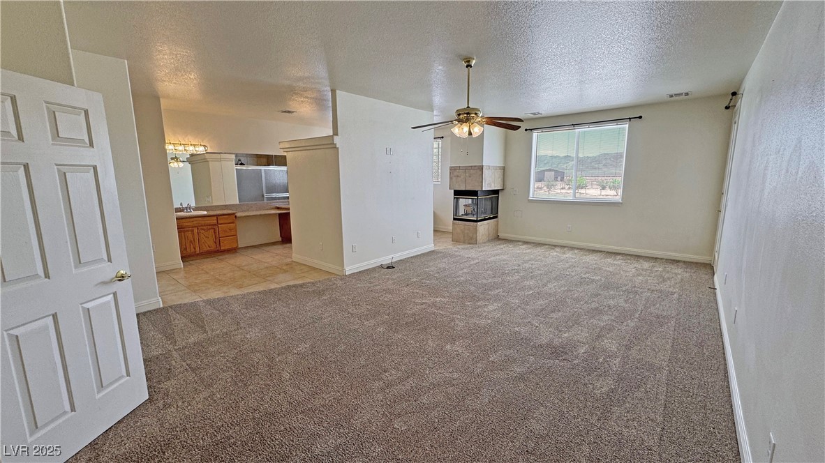 1771 Labrador Street Pahrump, NV 89048 - Photo 27 of 64 Unfurnished living room with light carpet, a ceiling fan, and a textured ceiling