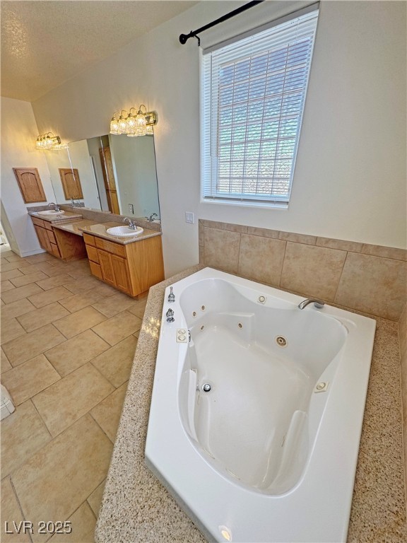 1771 Labrador Street Pahrump, NV 89048 - Photo 34 of 64 Full bath featuring a tub with jets, double vanity, tile patterned flooring, and a textured ceiling