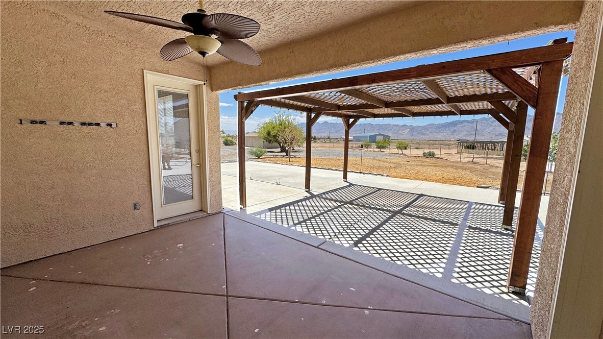 1771 Labrador Street Pahrump, NV 89048 - Photo 55 of 64 View of patio with a mountain view, a ceiling fan, and a pergola