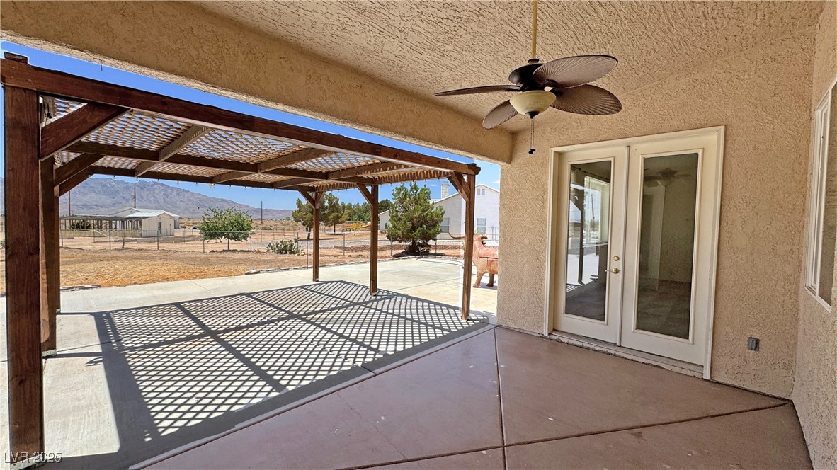 1771 Labrador Street Pahrump, NV 89048 - Photo 56 of 64 View of patio / terrace with a mountain view, ceiling fan, a pergola, and french doors