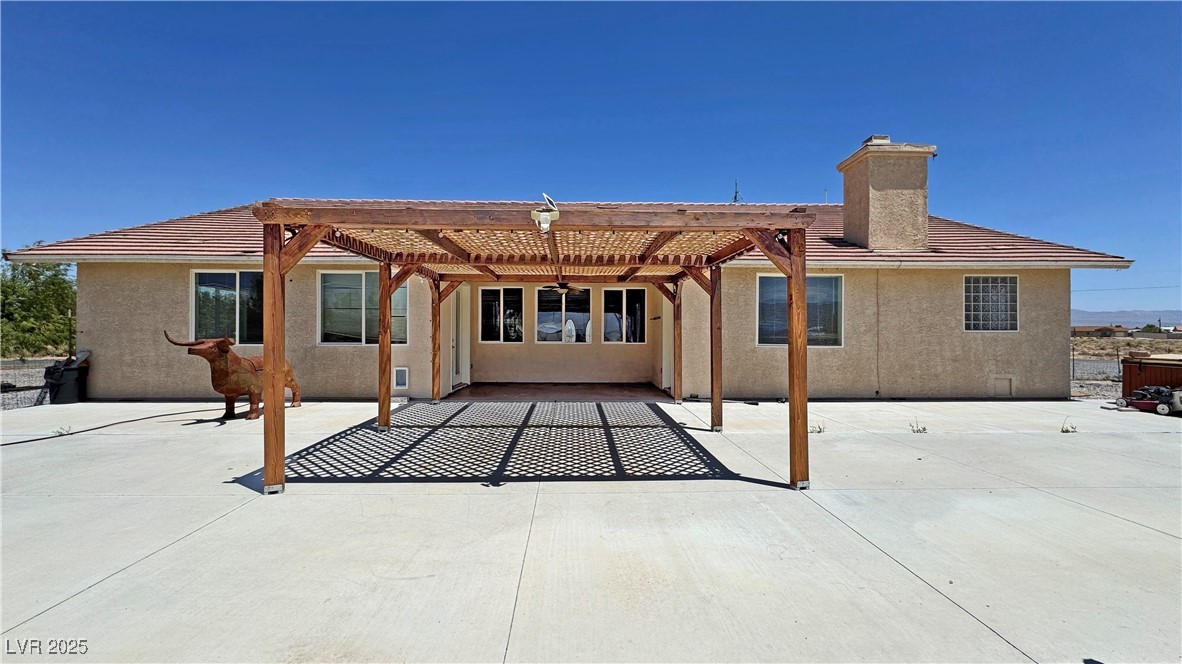 1771 Labrador Street Pahrump, NV 89048 - Photo 58 of 64 Rear view of property featuring a pergola, stucco siding, a chimney, and a patio