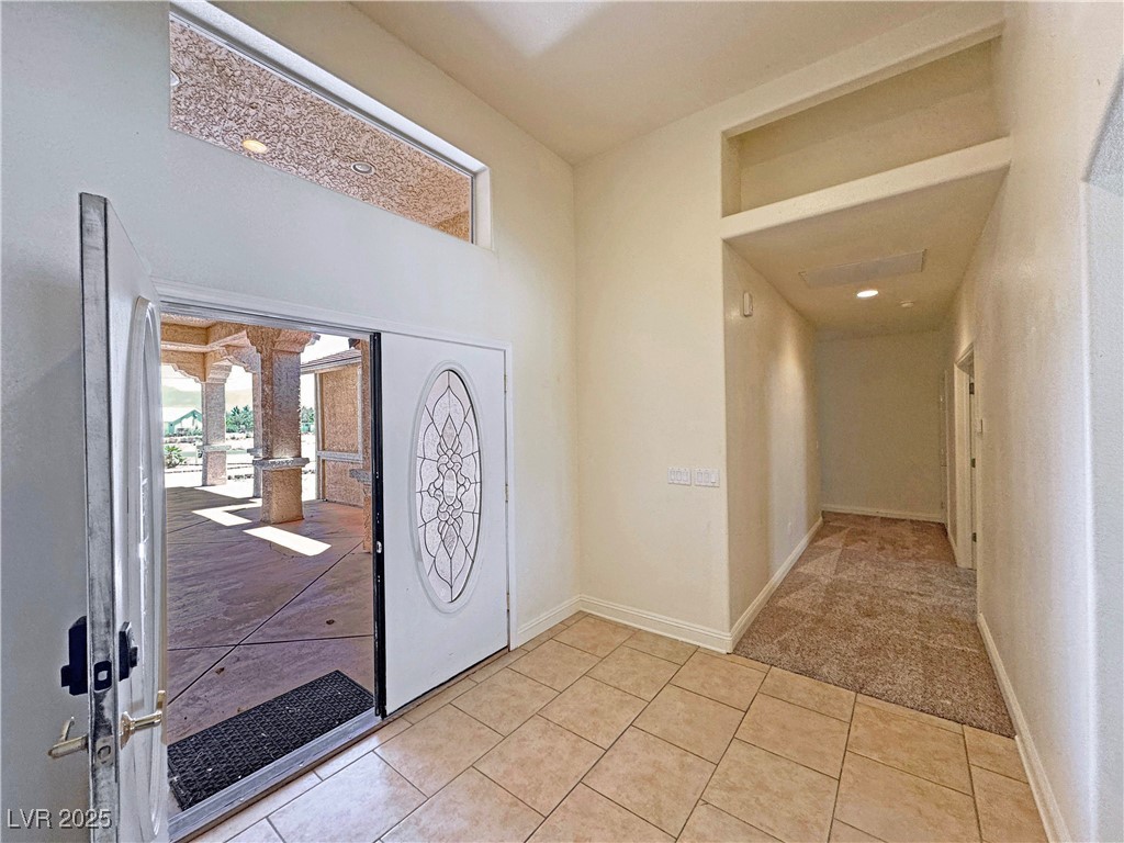 1771 Labrador Street Pahrump, NV 89048 - Photo 7 of 64 Entryway with light tile patterned flooring, light colored carpet, decorative columns, and a towering ceiling