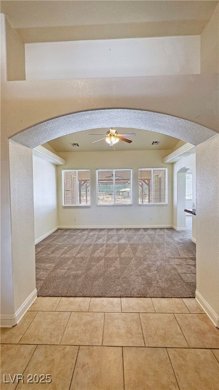 1771 Labrador Street Pahrump, NV 89048 - Photo 9 of 64 Empty room featuring light carpet, arched walkways, and plenty of natural light