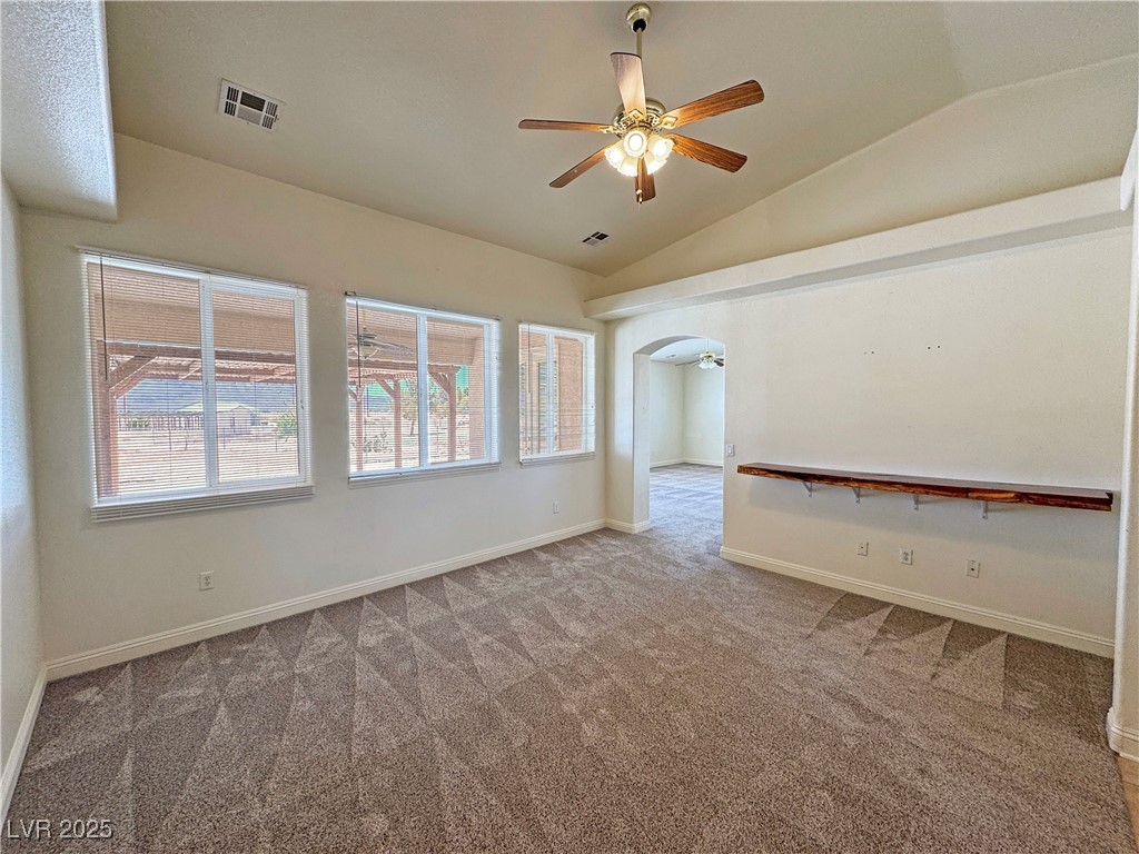 1771 Labrador Street Pahrump, NV 89048 - Photo 10 of 64 Unfurnished room with carpet flooring, lofted ceiling, a ceiling fan, and arched walkways