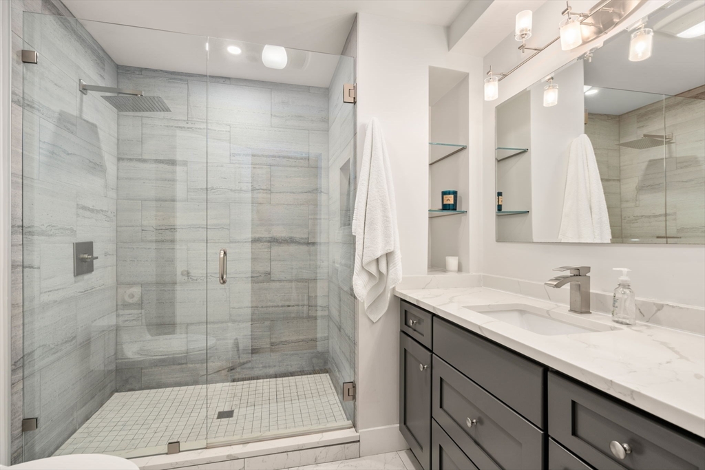 61 Silver Hill Road Weston, MA 02493 - Photo 28 of 39 a bathroom with a shower sink and mirror