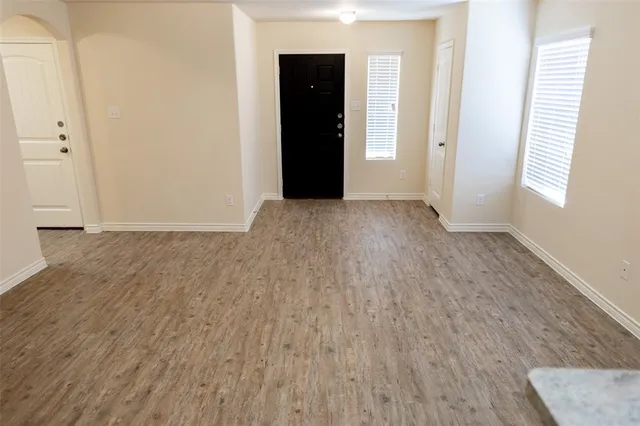 a view of an empty room with wooden floor