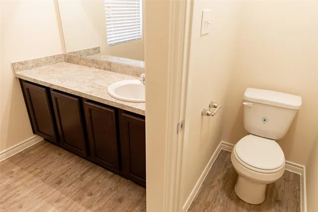 a bathroom with a granite countertop sink and a toilet