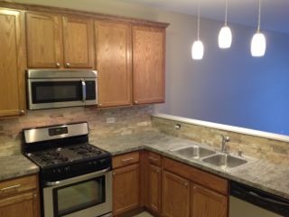 3144 Falling Waters Lane, Unit 3142 Lindenhurst, IL 60046 - Photo 2 of 16 a kitchen with granite countertop stainless steel appliances a stove a sink and a microwave
