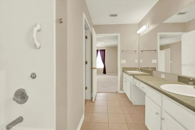a large bathroom with a granite countertop sink a mirror and a shower