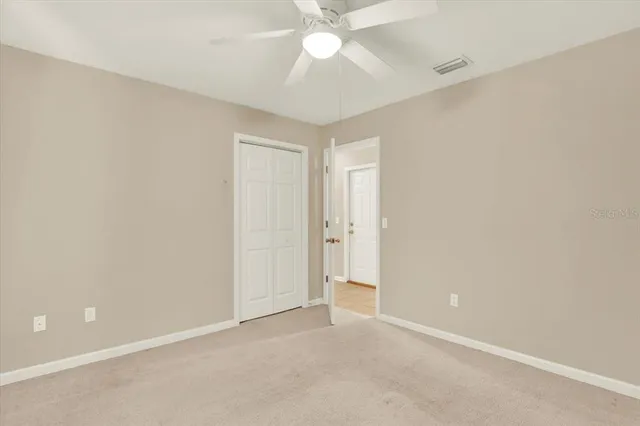 an empty room with a ceiling fan and a window