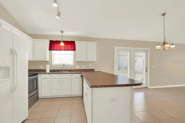 a kitchen with stainless steel appliances granite countertop a stove a sink dishwasher and a refrigerator