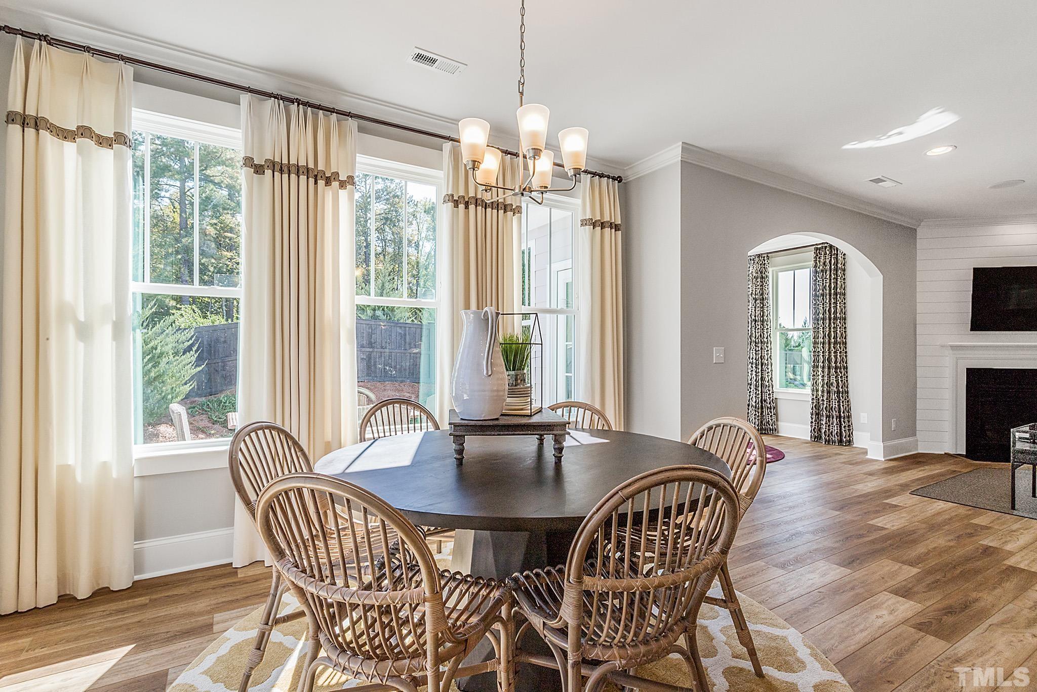 243 Oak Branch Trail Garner, NC 27529 - Photo 11 of 29 a dining room with furniture a chandelier and wooden floor