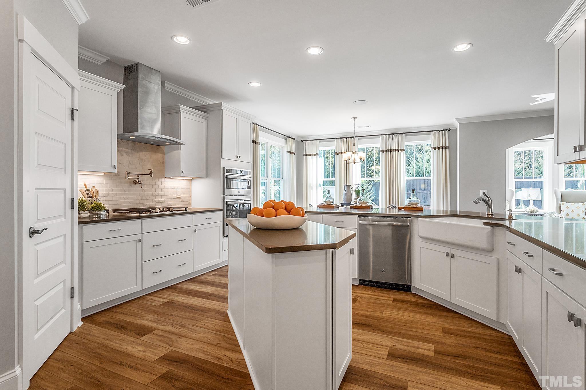 243 Oak Branch Trail Garner, NC 27529 - Photo 12 of 29 a kitchen with white cabinets and sink