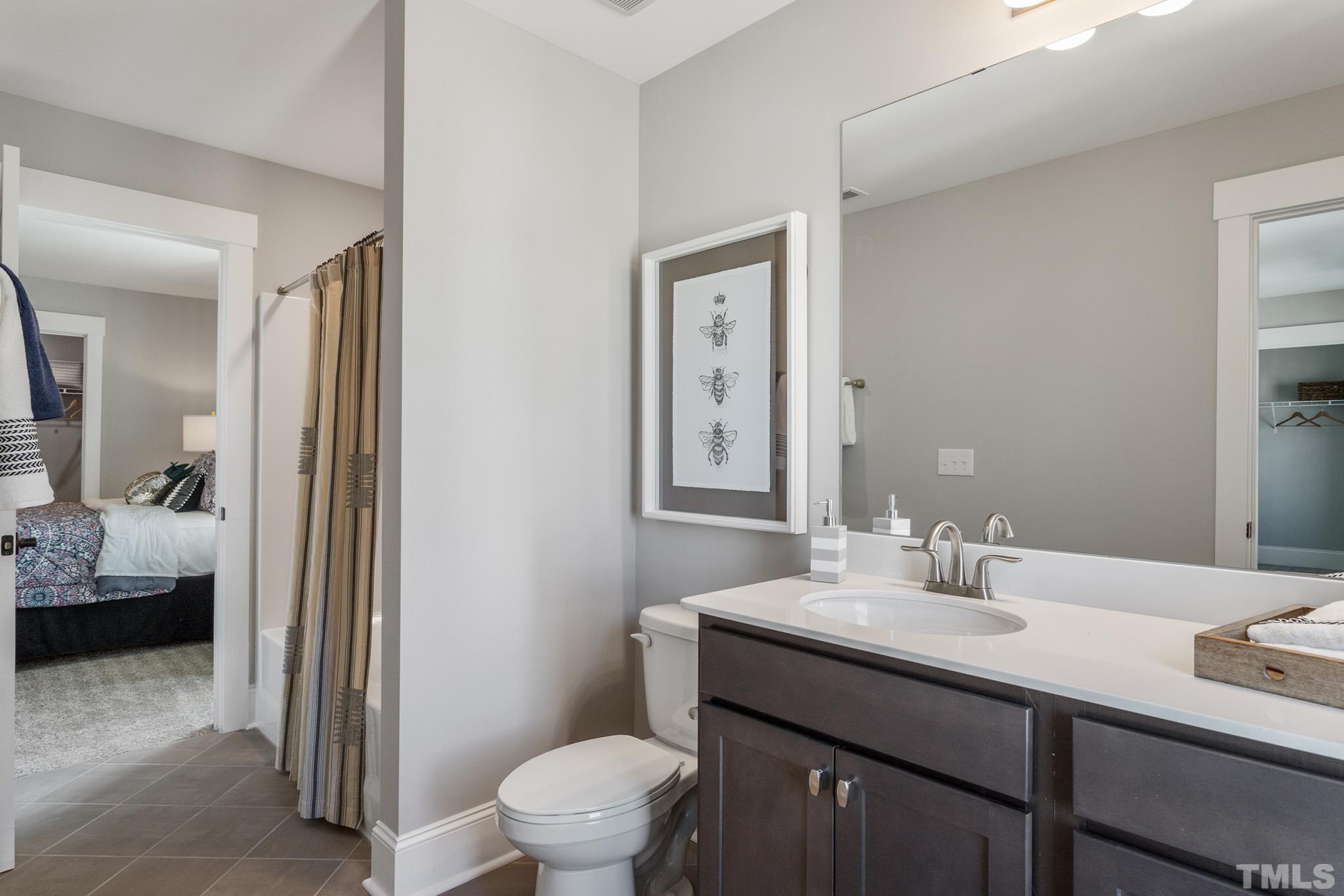 243 Oak Branch Trail Garner, NC 27529 - Photo 21 of 29 a bathroom with a sink a toilet and a mirror