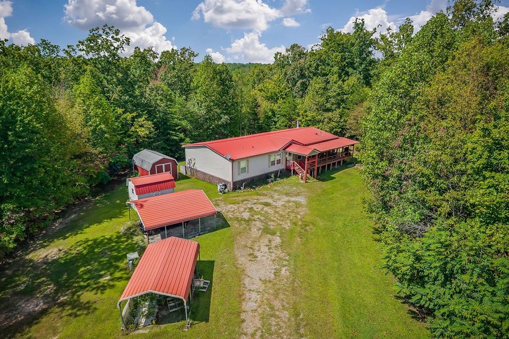 an aerial view of a house with swimming pool and red chairs