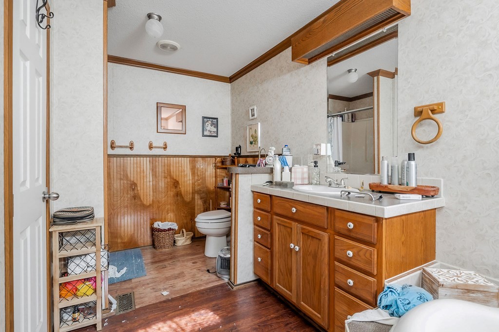 30211 White Oak Road Crawford, TN 38554 - Photo 16 of 24 a spacious bathroom with a granite countertop sink a toilet and a mirror