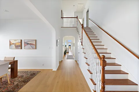 a view of staircase with wooden floor and white walls