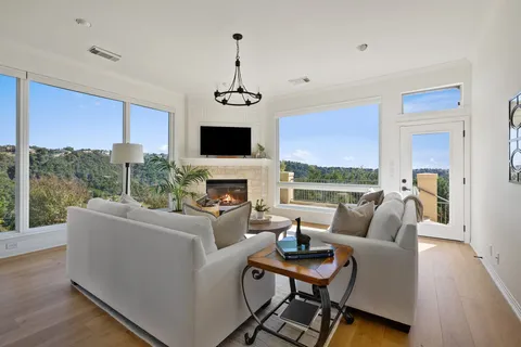 a living room with furniture a flat screen tv and a large window