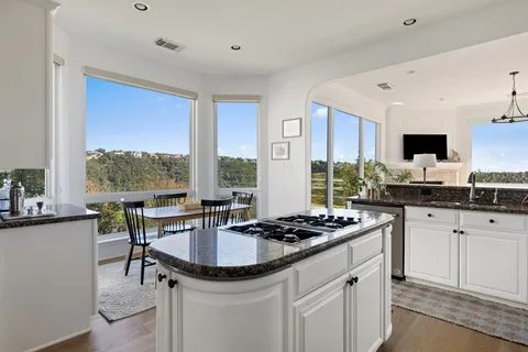 a kitchen with granite countertop a sink stove and cabinets