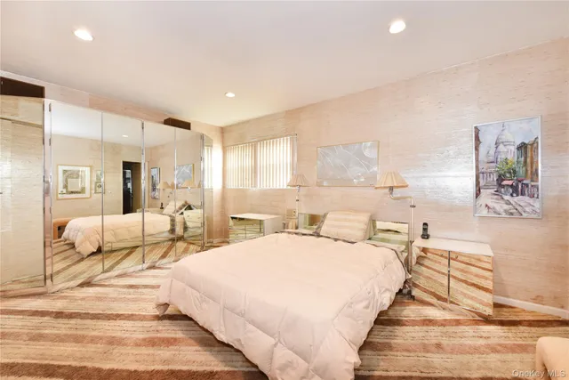 a large bedroom with a bed and lamp