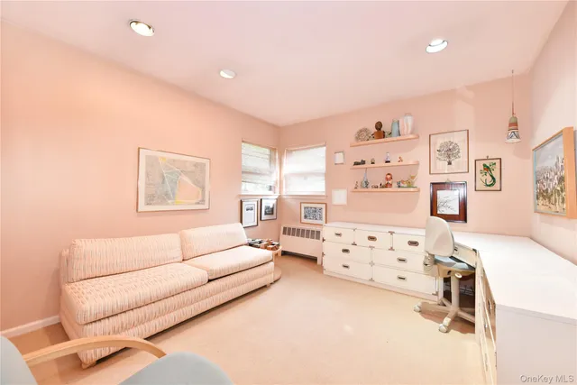 a living room with furniture and a dresser with rug