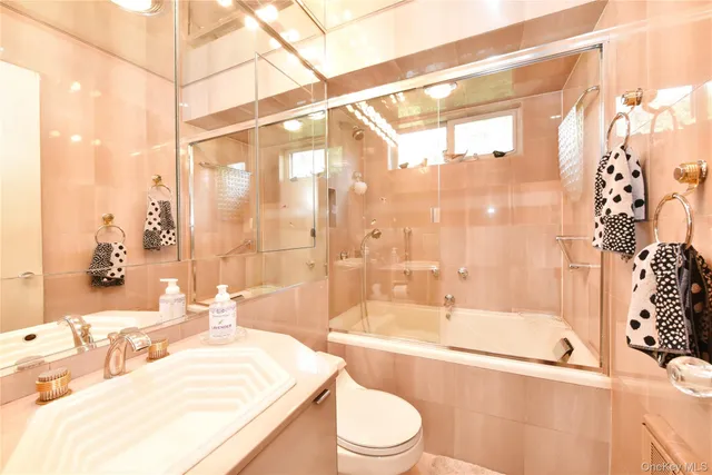 a bathroom with a bathtub shower sink vanity and toilet