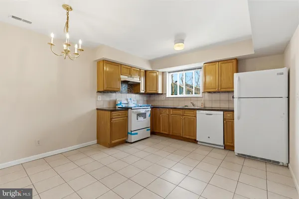 a kitchen with a refrigerator a sink dishwasher and a stove with a dining table