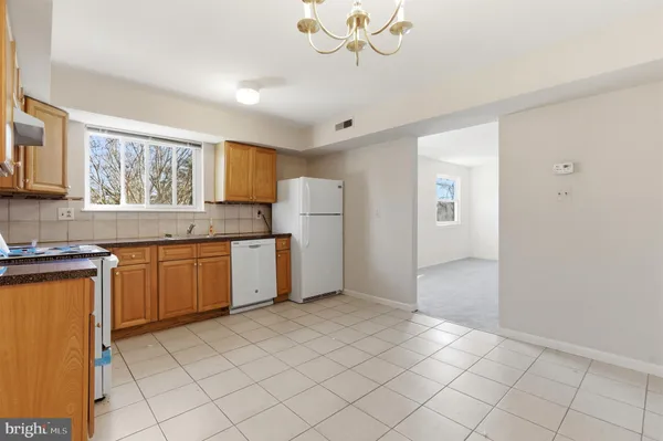 a kitchen with granite countertop a stove a sink and a refrigerator