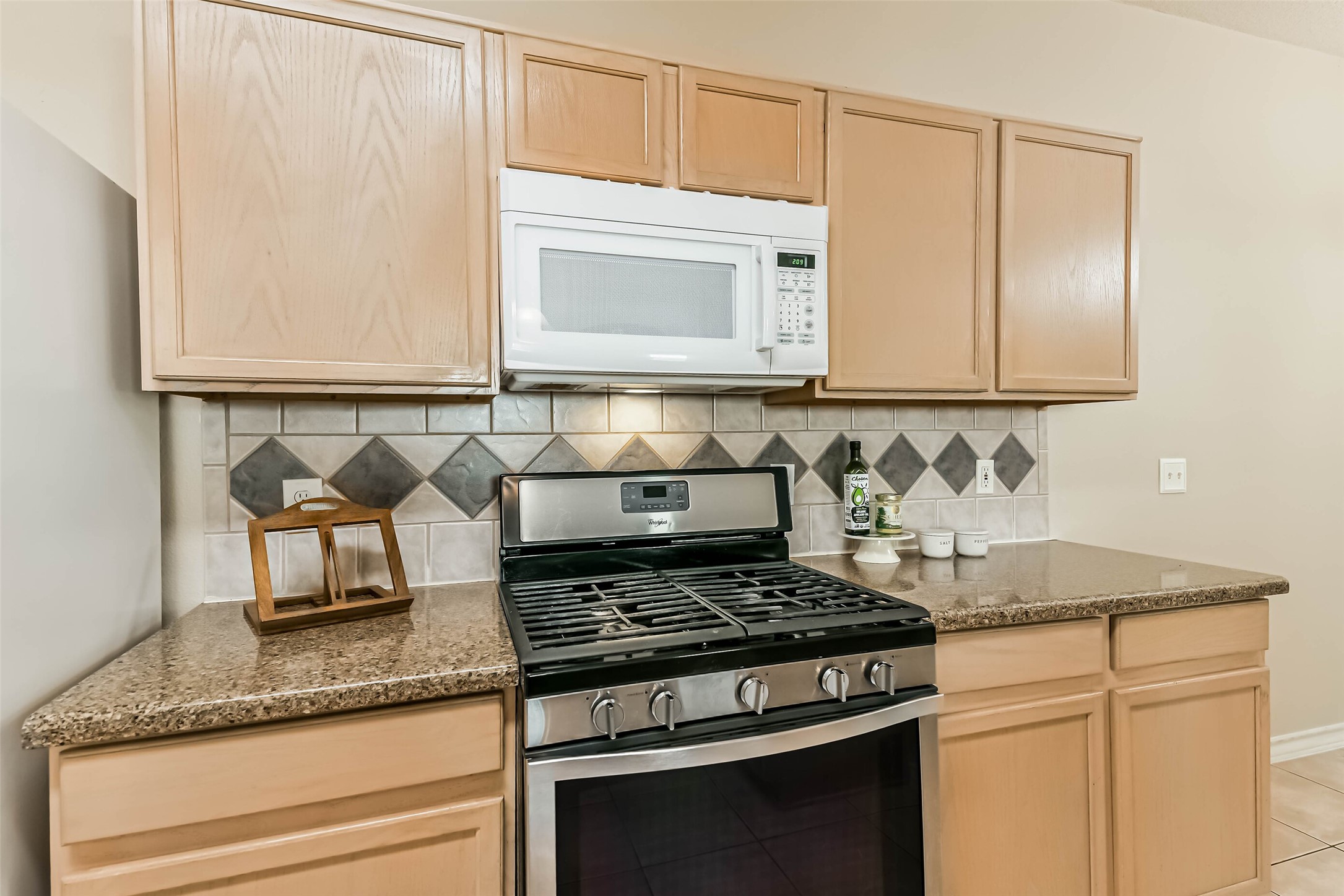 18239 Trinity Knoll Way Humble, TX 77346 - Photo 15 of 38 a kitchen with granite countertop white cabinets and a stove top oven