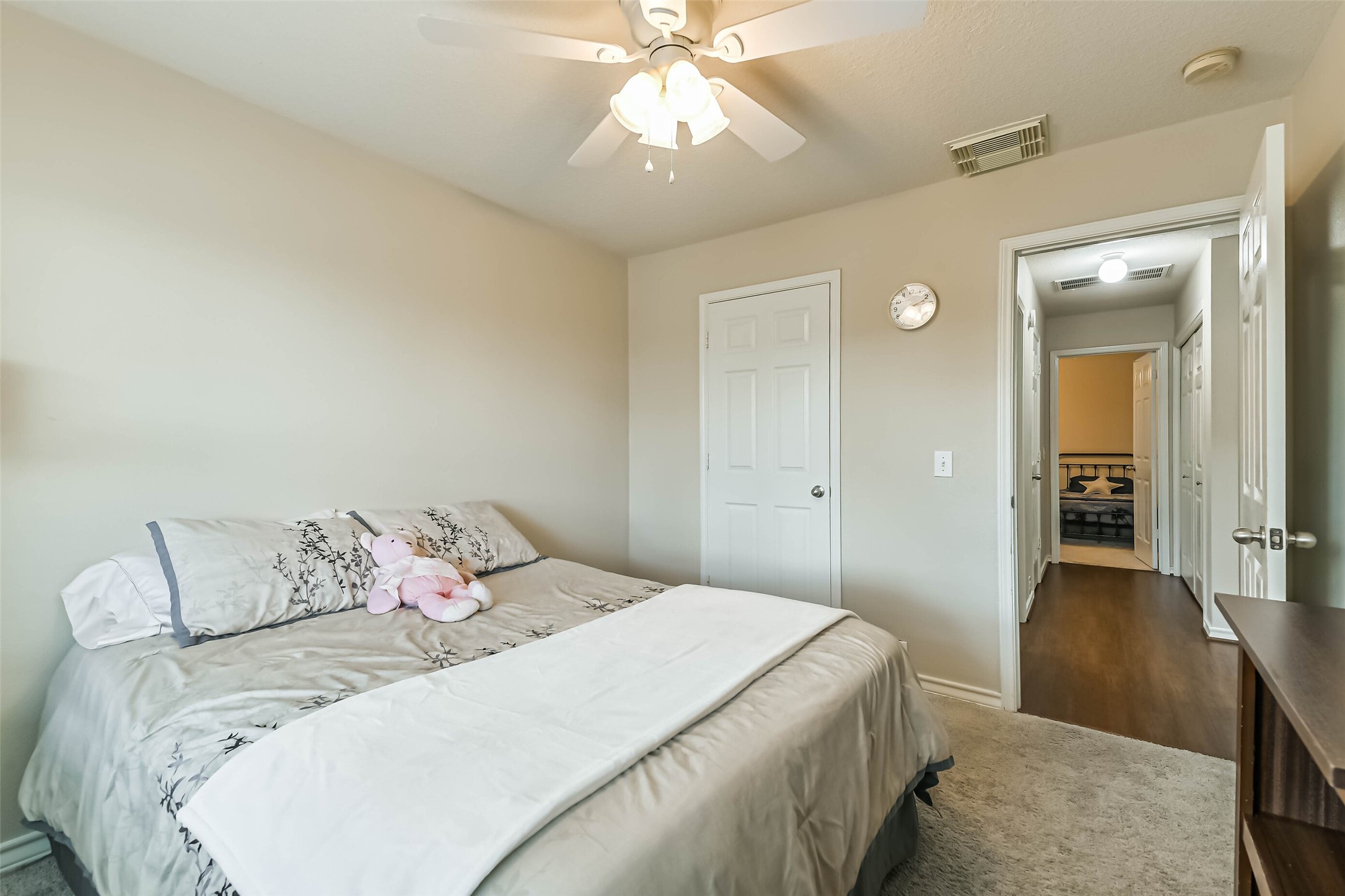 18239 Trinity Knoll Way Humble, TX 77346 - Photo 25 of 38 a bedroom with a bed and a chandelier