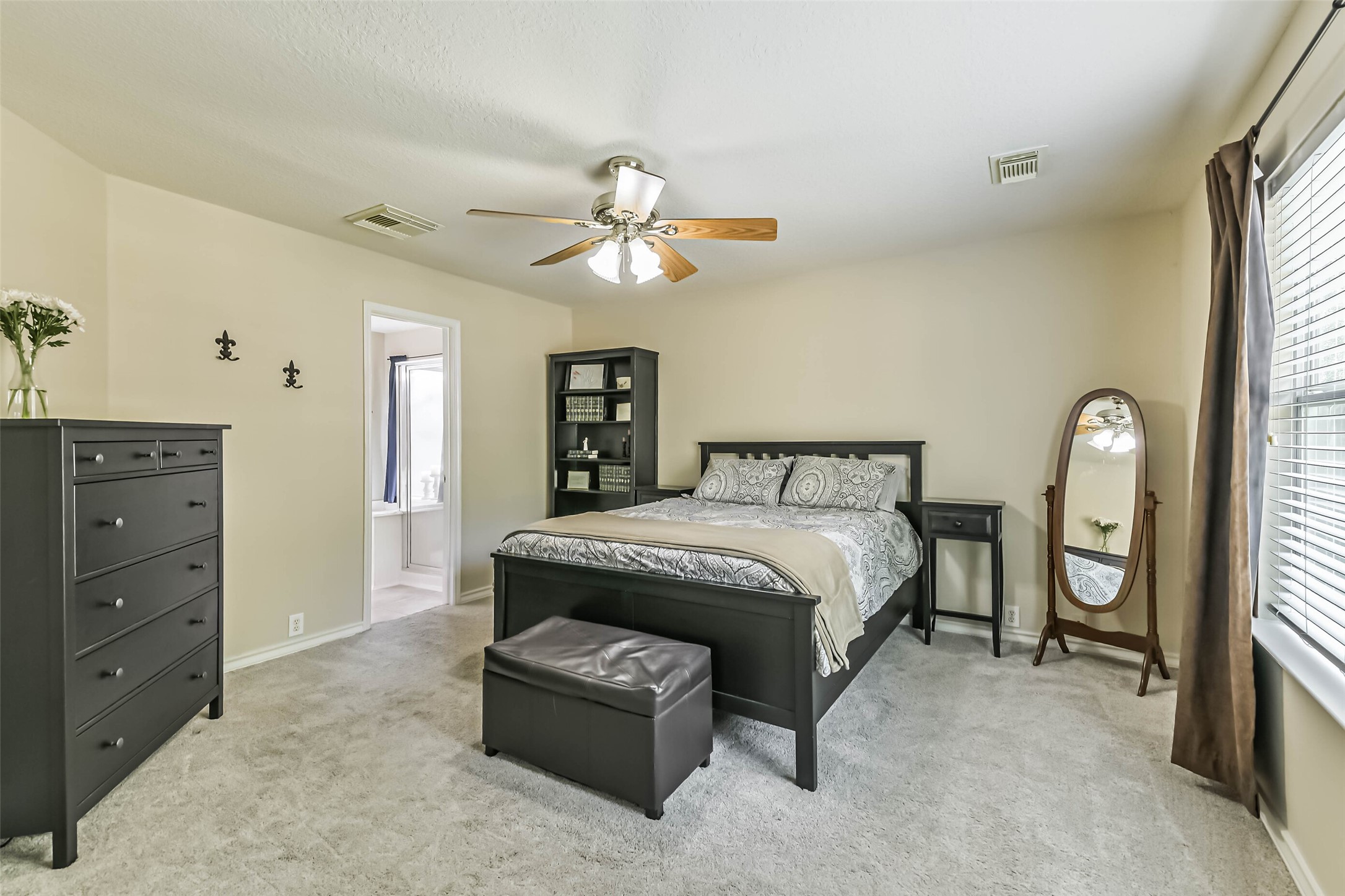 18239 Trinity Knoll Way Humble, TX 77346 - Photo 31 of 38 a bedroom with a bed and a chandelier