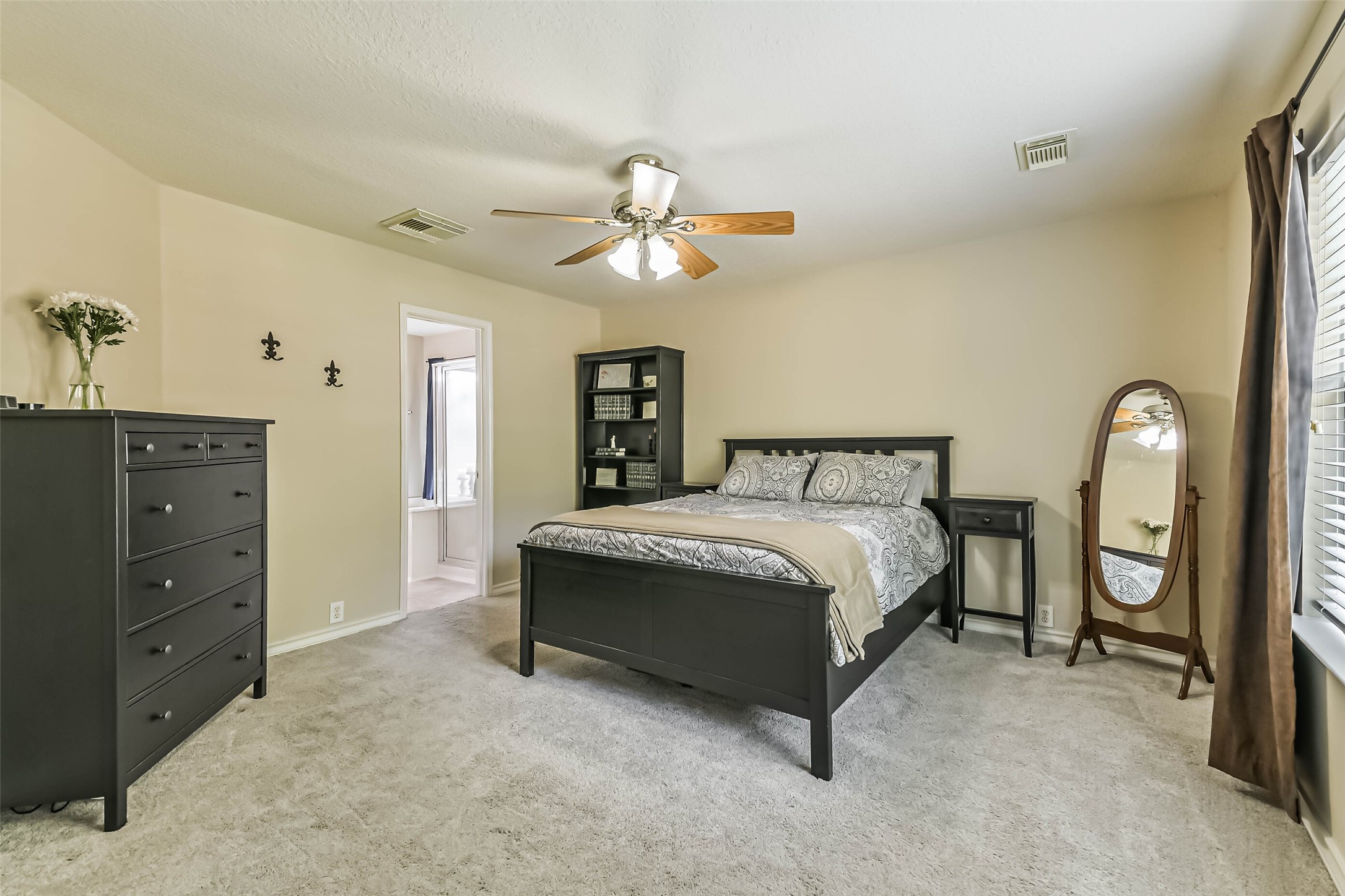 18239 Trinity Knoll Way Humble, TX 77346 - Photo 32 of 38 a bedroom with a bed and a chandelier