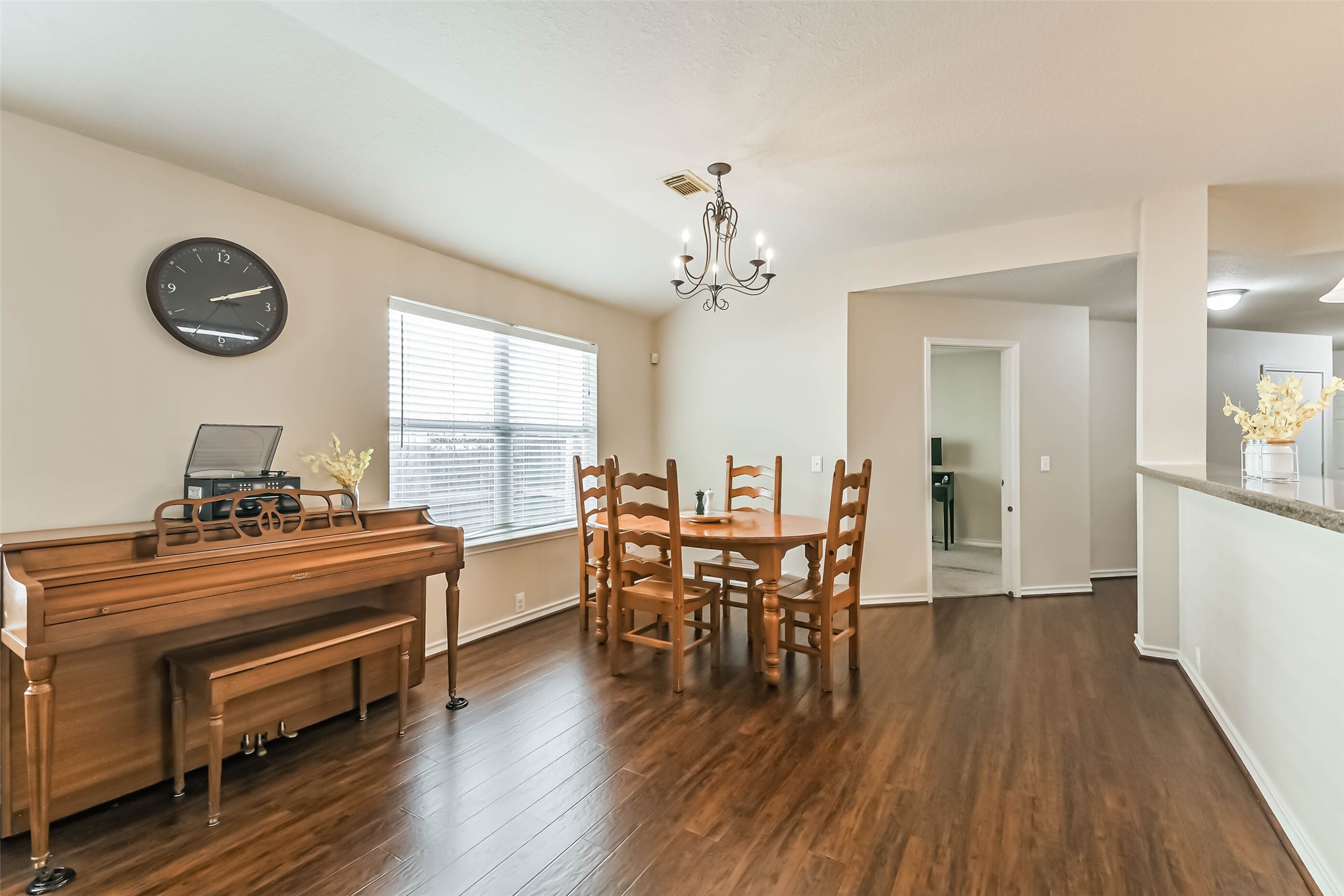 18239 Trinity Knoll Way Humble, TX 77346 - Photo 5 of 38 a dining room with wooden floor a chandelier a wooden table and chairs